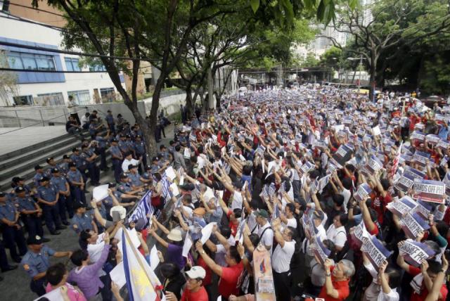 Protesters face the Chinese Consulate to display their anti Chinese message during a Philippines Independence Day rally in the financial district of Makati city east of Manila, Philippines, Friday, June 12, 2015. The protesters condemned the recent reclamation of land by China in the disputed Spratlys group of islands on the South China Sea. (AP Photo/Bullit Marquez)